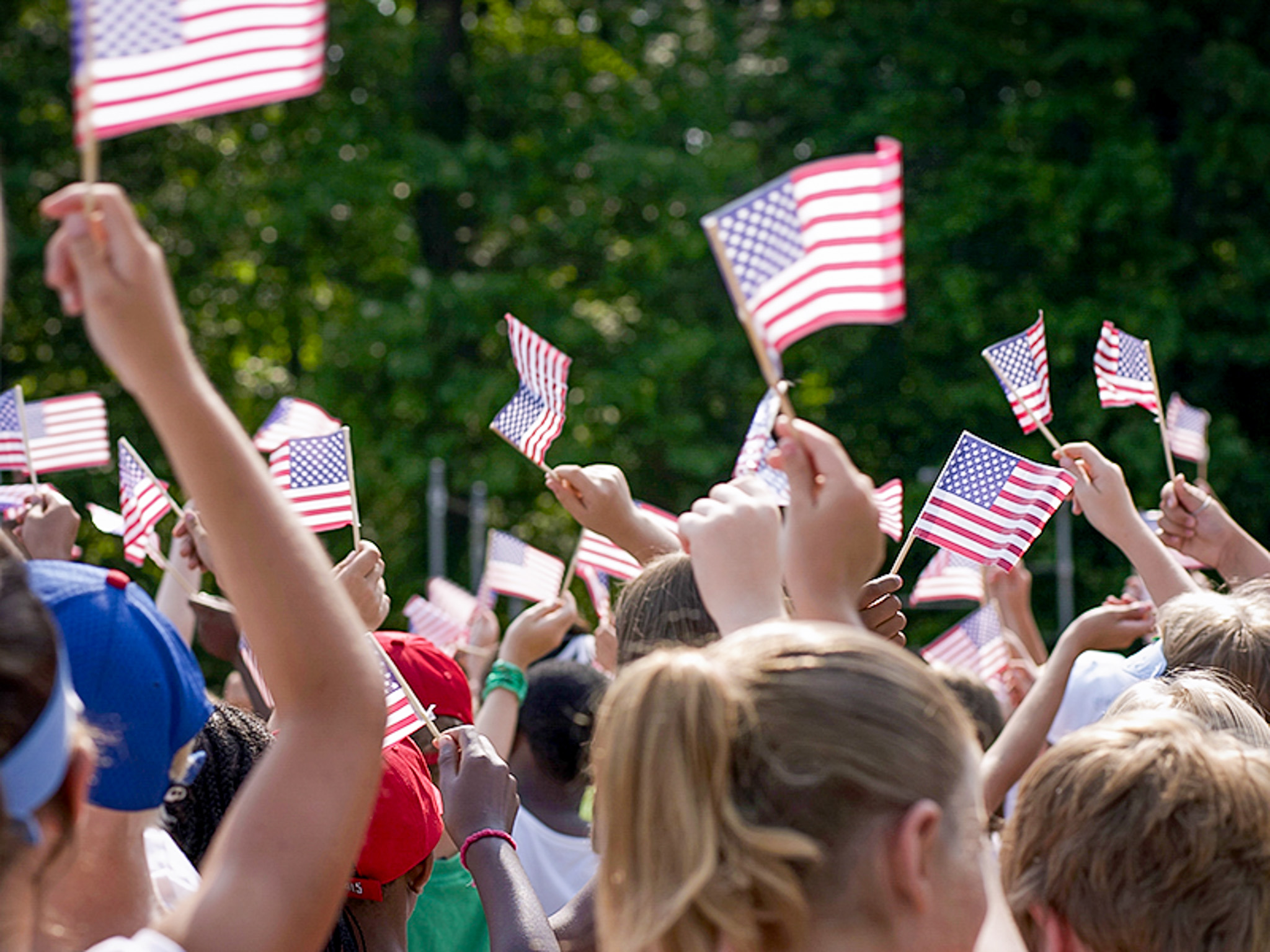 Students gathered at TP USA event, holding American flags.
