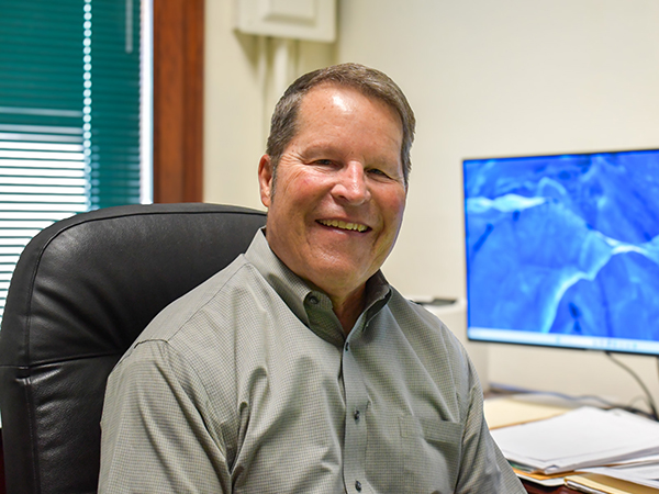 Roger Nissly sits at his desk in his office. 