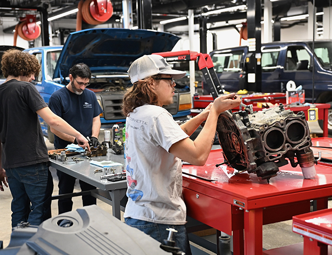 Automotive Technology two students and instuctor working on engines