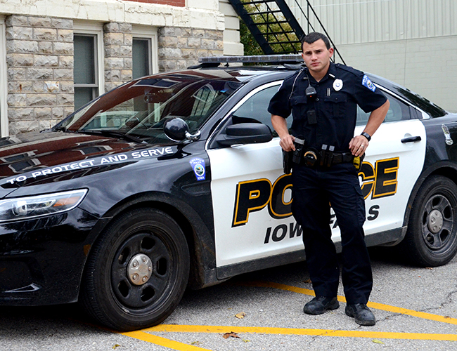 Criminal Justice police officer in front of squad car