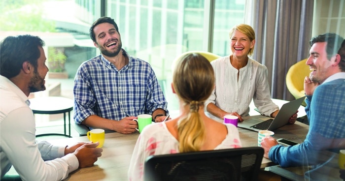 group-sitting-around-table-laughing