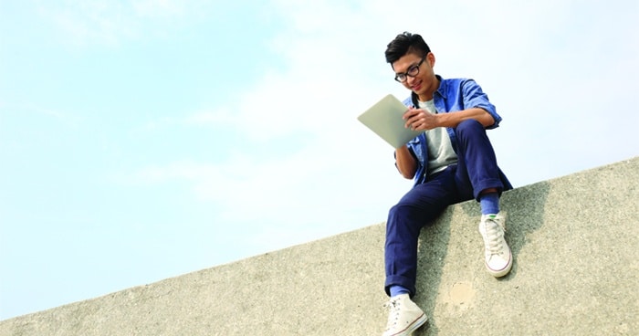 man-sitting-on-wall-with-laptop