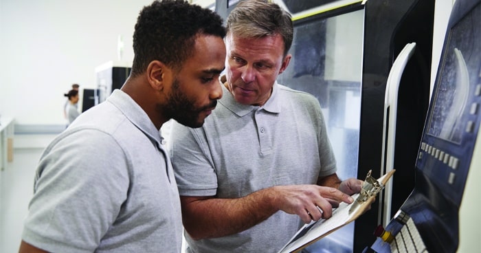 two-men-talking-with-clipboard-looking-at-computer-screen